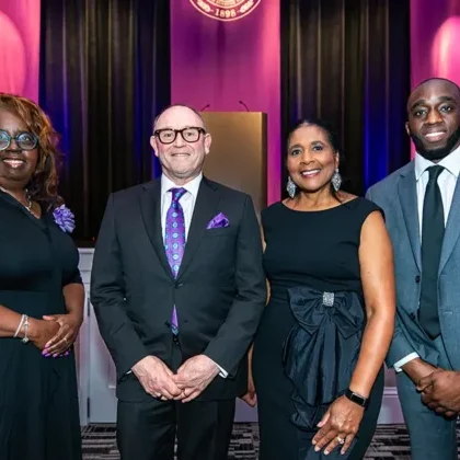 Lisa Green, D.O.'91, M.P.H., Steve McManus, Angela L. Walker Franklin, Ph.D., and Ruffin Tchakounte, D.O.’22, M.S.A.’18, pose for a photo in front of the stage at the 21st annual Glanton Event.